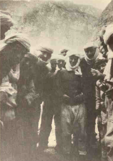 A group of men surrounding the camera looking down at it