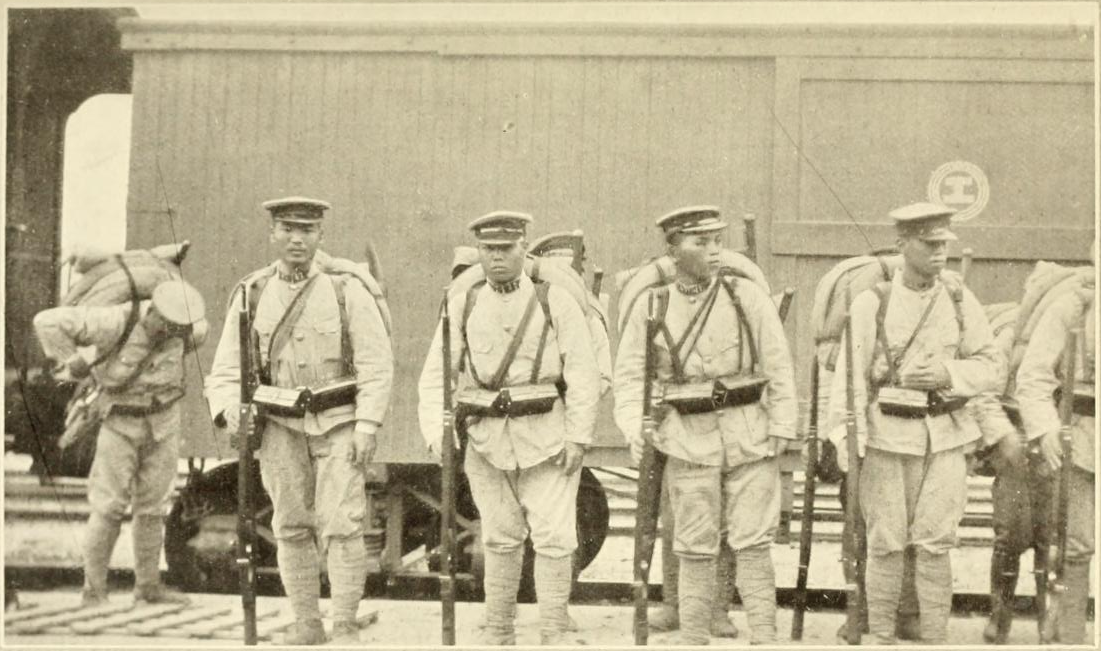 Photo of Japanese troops standing in line in front of a train