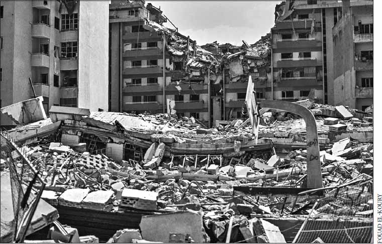 black and white picture of building partly collapsed and ground covered with rubble