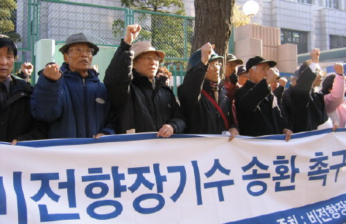 People stand in a row at a demonstration calling for a second repatriation of unconverted long-term prisoners in south Korea. Their Korean-language sign reads "비전향장기수 송환 촉구". (Meaning "Call for repatriation of non-converted long-term prisoners")