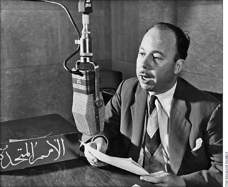 Black and white photo of Ismail al-Khalidi sitting in a room speaking into a microphone