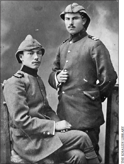 Husayn and Hasan-al-Khalidi, one standing one sitting in uniform looking at the camera posing for a portrait