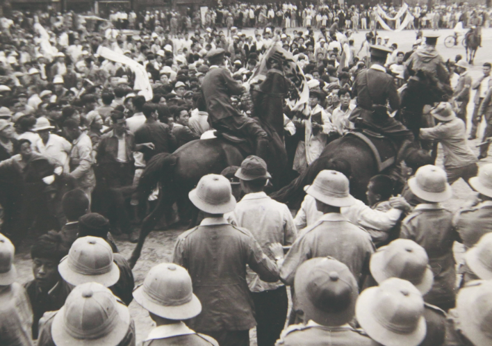 Mounted police officers of the U.S. Military government make their way through a crowd on the mainland.(3).png