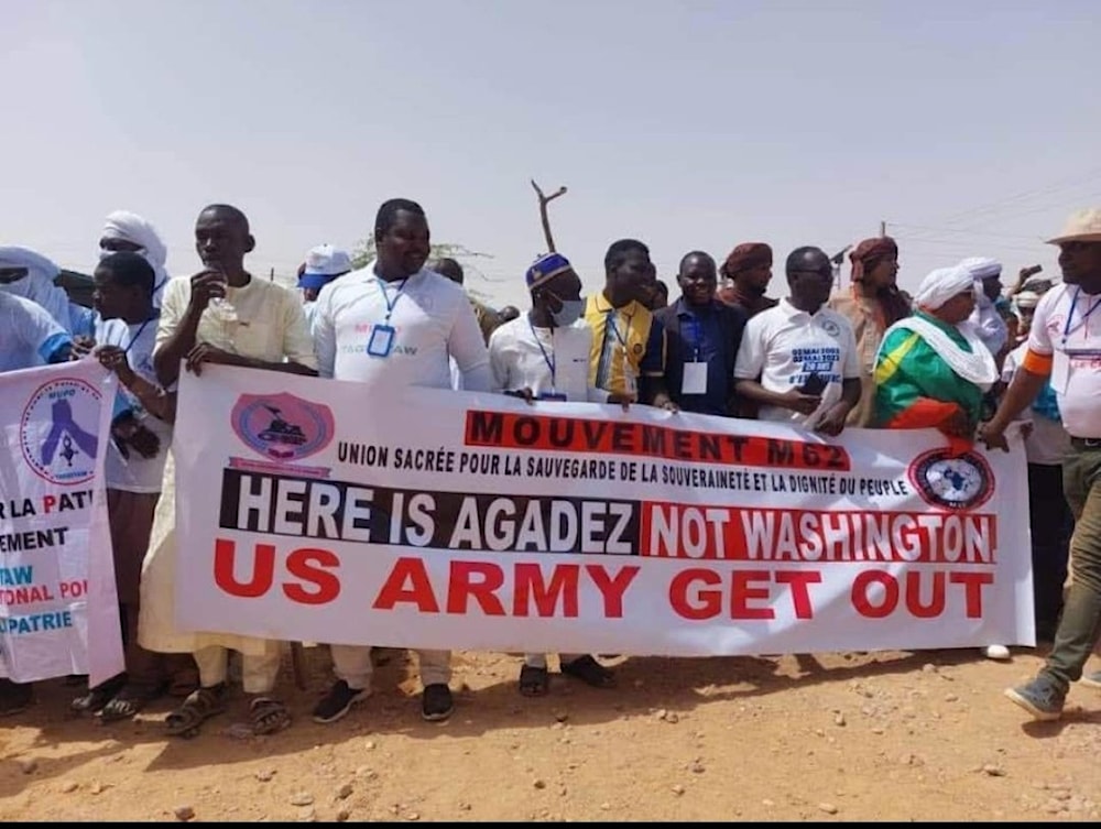 Demonstrators in Niger hold a French and English language sign which says: "Mouvement M62 Union sacrée pour la sauvegarde de la souveraineté et la dignité du peuple Here is Agadez not Washington US Army Get Out"