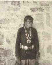 a person standing against brick wall and looking to the left