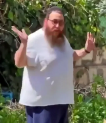 Screenshot of Fauci standing in a garden and holding up his hands as he responds to Muna al-Kurd.