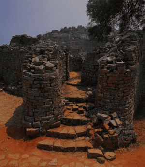 A photo showing a series of stone steps between stone walls forming a passageway in the ruins.
